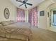 Relaxing bedroom with ceiling fan, warm paint and carpet, and natural light at 11429 S Wilson Ln, Goodyear, AZ 85338