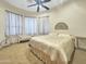 Relaxing bedroom with ceiling fan, warm paint and carpet, and bench seating at 11429 S Wilson Ln, Goodyear, AZ 85338