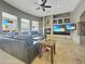 Inviting living room with ample seating, built-in shelving, stone fireplace, and large windows at 11429 S Wilson Ln, Goodyear, AZ 85338