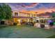 Evening view of a home with putting green, pool, and stunning sunset at 13007 W Lowden Rd, Peoria, AZ 85383