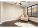 Bright bedroom with plush chair, wood floors, and large window at 13007 W Lowden Rd, Peoria, AZ 85383