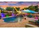 Stunning pool area at sunset with a waterfall and lounge chairs at 13007 W Lowden Rd, Peoria, AZ 85383