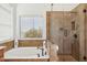 Inviting bathroom showcasing a soaking tub with elegant fixtures and a separate glass-enclosed shower at 13248 N 12Th Pl, Phoenix, AZ 85022