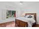 Comfortable bedroom with a wooden bed frame, and a window view of the pool and lush landscaping at 13248 N 12Th Pl, Phoenix, AZ 85022