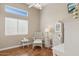 Serene bedroom decorated with white furniture, including a wicker chair and desk, offering a peaceful retreat at 13248 N 12Th Pl, Phoenix, AZ 85022