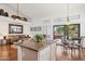 Open-concept kitchen with granite island, dining area, and a seamless transition to the living room and outdoor pool view at 13248 N 12Th Pl, Phoenix, AZ 85022