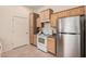 Compact kitchen with stainless steel refrigerator, range, and wooden cabinetry with laminate countertop at 14575 W Mountain View Blvd # 11222, Surprise, AZ 85374