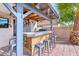 Covered patio with outdoor kitchen and bar stools at 14885 W Caribbean Ln, Surprise, AZ 85379