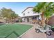 Artificial turf backyard with outdoor kitchen and play vehicles at 14885 W Caribbean Ln, Surprise, AZ 85379