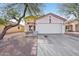 Single-story home with a two-car garage and landscaped front yard at 14885 W Caribbean Ln, Surprise, AZ 85379