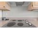 Close-up of a smooth cooktop with four burners, set into a speckled countertop, under matching cabinets at 15704 W Sentinel Dr, Sun City West, AZ 85375