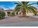 Single-story home with terracotta tile roof, desert landscaping, and a large palm tree at 15704 W Sentinel Dr, Sun City West, AZ 85375