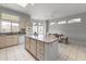 Bright kitchen featuring a central island, tile floors, and ample natural light from the large windows at 15704 W Sentinel Dr, Sun City West, AZ 85375