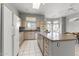 Open kitchen featuring beige cabinets, a large island, and white appliances, with a view of the dining area at 15704 W Sentinel Dr, Sun City West, AZ 85375