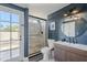 Modern bathroom with a glass-enclosed shower, stylish vanity, and a door leading to the exterior at 15857 N 51St Pl, Scottsdale, AZ 85254