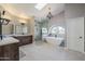 Bright primary bathroom featuring dual vanities, a soaking tub, glass enclosed shower and a chandelier at 15857 N 51St Pl, Scottsdale, AZ 85254