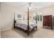 Comfortable bedroom with a four-poster bed, shutters, and side table at 17061 W Peregrine Ln, Surprise, AZ 85387