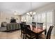 Open-concept dining area with a chandelier, shuttered windows, and seamless access to the living room at 17061 W Peregrine Ln, Surprise, AZ 85387