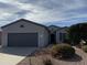 One-story home with a gray exterior, two-car garage, and well-manicured landscaping at 17061 W Peregrine Ln, Surprise, AZ 85387