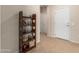 Hallway showcasing neutral walls, tile flooring, and a decorative wooden shelving unit at 17061 W Peregrine Ln, Surprise, AZ 85387