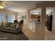 Living room with a gray couch and view into kitchen and dining area at 17061 W Peregrine Ln, Surprise, AZ 85387