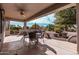 Covered patio with stamped concrete flooring, ceiling fan, and outdoor dining set, perfect for entertaining at 17061 W Peregrine Ln, Surprise, AZ 85387