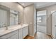 Bathroom features double sinks with gold-toned fixtures and a view of the carpeted bedroom at 17299 W Desert Sage Dr, Goodyear, AZ 85338