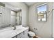 Well-lit bathroom features a single sink vanity, toilet, shower-tub combo and a window at 17299 W Desert Sage Dr, Goodyear, AZ 85338