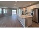 Spacious kitchen with island, stainless steel appliances, and light wood floors at 17299 W Desert Sage Dr, Goodyear, AZ 85338