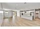 Open-concept living area with wood floors, gray walls, and seamless flow into a modern kitchen at 17299 W Desert Sage Dr, Goodyear, AZ 85338