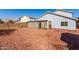 View of home's backyard with a large gravel area, small desert landscaping, and view of the enclosed patio at 1937 W Burgess Ln, Phoenix, AZ 85041