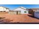 Wide view of backyard with gravel area, small cactus landscape, and enclosed patio of the home at 1937 W Burgess Ln, Phoenix, AZ 85041