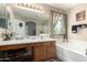 Bathroom featuring double sink vanity, stained glass window and soaking tub at 1937 W Burgess Ln, Phoenix, AZ 85041