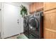 Laundry room with a front-load washer and dryer and upper cabinets for storage at 1937 W Burgess Ln, Phoenix, AZ 85041