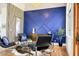 Elegant dining area with unique blue accent wall, modern furniture, and hardwood flooring at 24084 N 77Th St, Scottsdale, AZ 85255