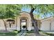 Inviting front entrance with decorative stone walkway and arched doorway, complemented by mature desert landscaping at 24084 N 77Th St, Scottsdale, AZ 85255