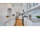 Modern kitchen featuring white cabinetry, marble countertops, stainless steel appliances, and hardwood floors at 24084 N 77Th St, Scottsdale, AZ 85255