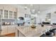 Open-concept kitchen with a large island, marble countertops, white cabinetry, and pendant lighting at 24084 N 77Th St, Scottsdale, AZ 85255