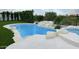 Backyard pool with rock waterfall feature, surrounded by white tile and green lawn at 24084 N 77Th St, Scottsdale, AZ 85255