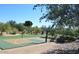 Community sports court with basketball hoops, green turf, benches, and playground at 24084 N 77Th St, Scottsdale, AZ 85255