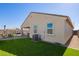 Exterior view of the home showcasing artificial turf, a covered patio, and well-maintained landscaping at 24338 W Albeniz Pl, Buckeye, AZ 85326