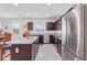 Modern kitchen featuring stainless steel appliances, granite countertops, and dark wood cabinets at 24338 W Albeniz Pl, Buckeye, AZ 85326