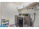 Laundry room featuring new stainless steel washer and dryer and shelving at 24338 W Albeniz Pl, Buckeye, AZ 85326