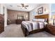 Spacious bedroom with a carpet, a ceiling fan, and rustic-style furniture at 24338 W Albeniz Pl, Buckeye, AZ 85326