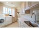 Bright laundry room with modern appliances and cabinets at 25453 N 113Th Way, Scottsdale, AZ 85255