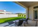 Inviting covered patio with outdoor seating overlooks a well-manicured backyard with lush green grass at 2706 E Lovebird Ln, Gilbert, AZ 85297