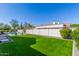 Expansive backyard with lush grass, mature landscaping, privacy wall, and inviting pool with lounge chairs at 2706 E Lovebird Ln, Gilbert, AZ 85297