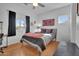 Bedroom with hardwood flooring, a ceiling fan, a large window, and a gray bedframe at 311 W Georgia Ave, Phoenix, AZ 85013