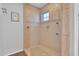 Modern shower features a glass door, neutral tile, window, and decorative accents for a clean and stylish space at 311 W Georgia Ave, Phoenix, AZ 85013