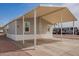 Exterior of single-story home features carport with gravel landscaping and bright blue sky at 320 E Mckellips Rd # 50, Mesa, AZ 85201